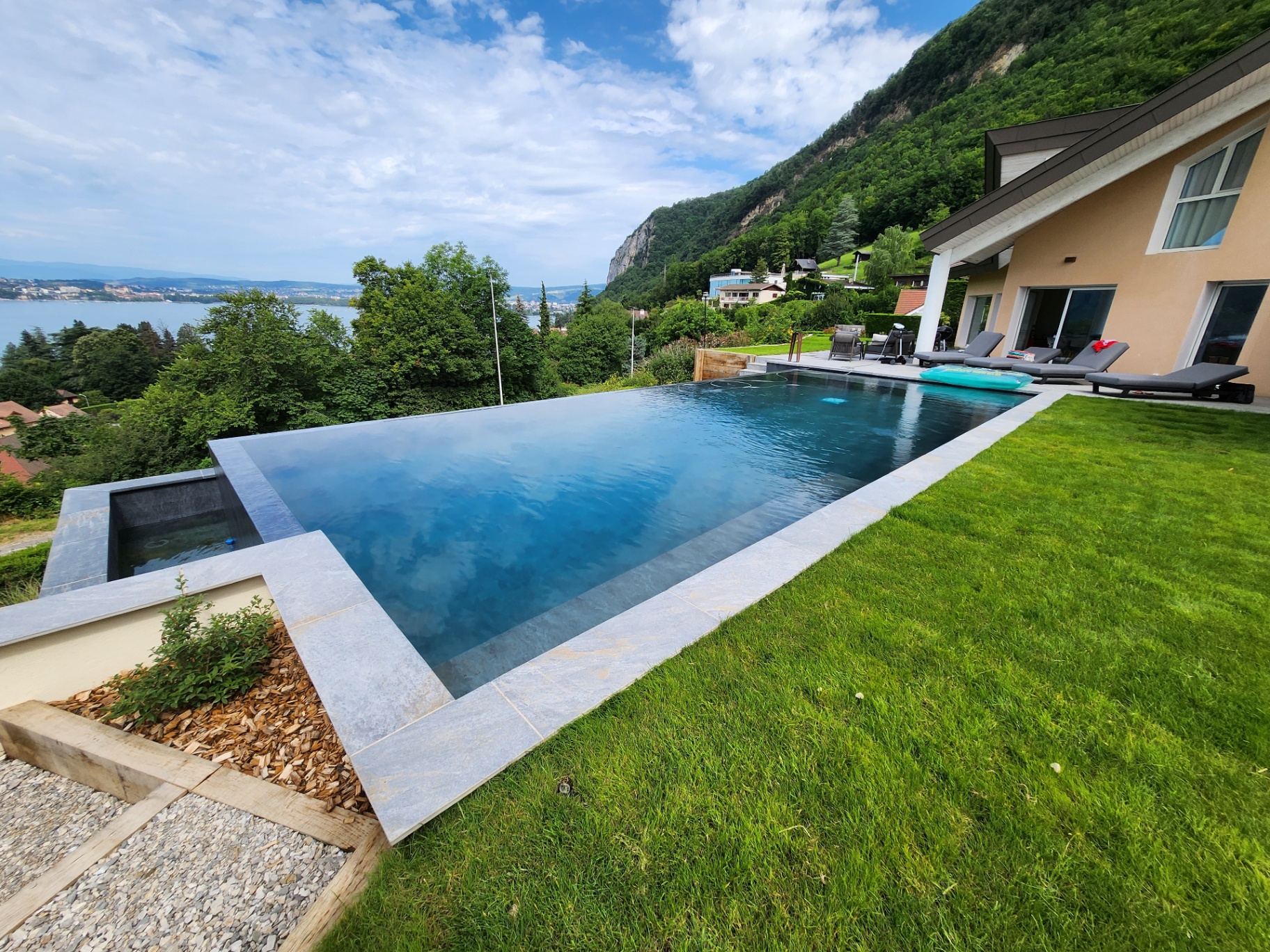 Piscine à débordement contemporaine avec vue sur le lac et les montagnes